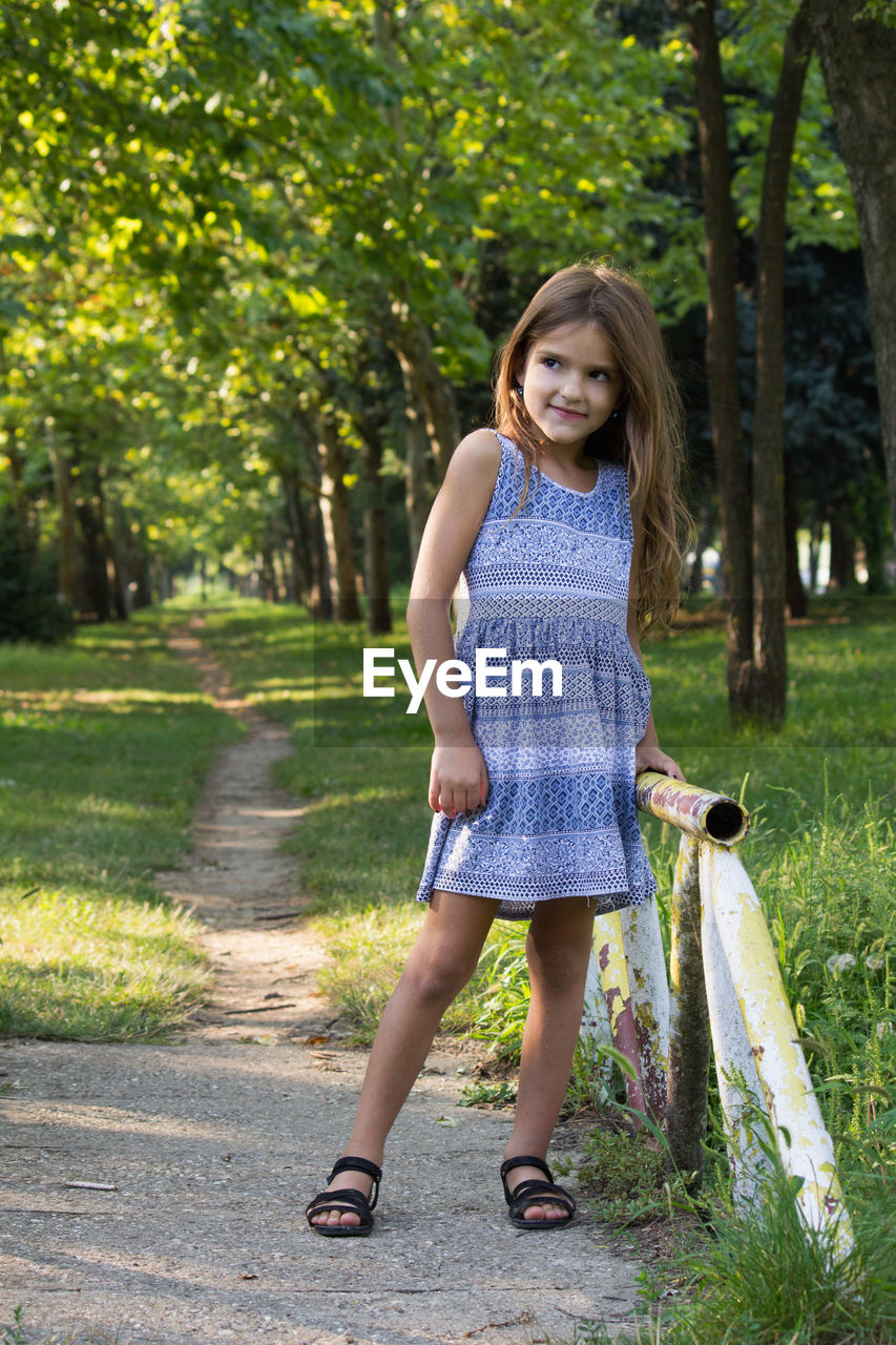 Portrait of smiling girl wearing hat looking away at park