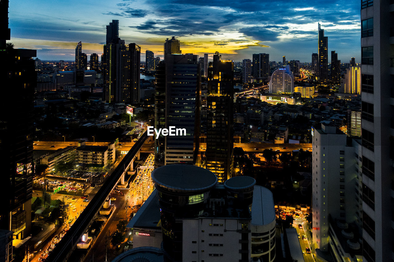 Illuminated buildings in city against sky