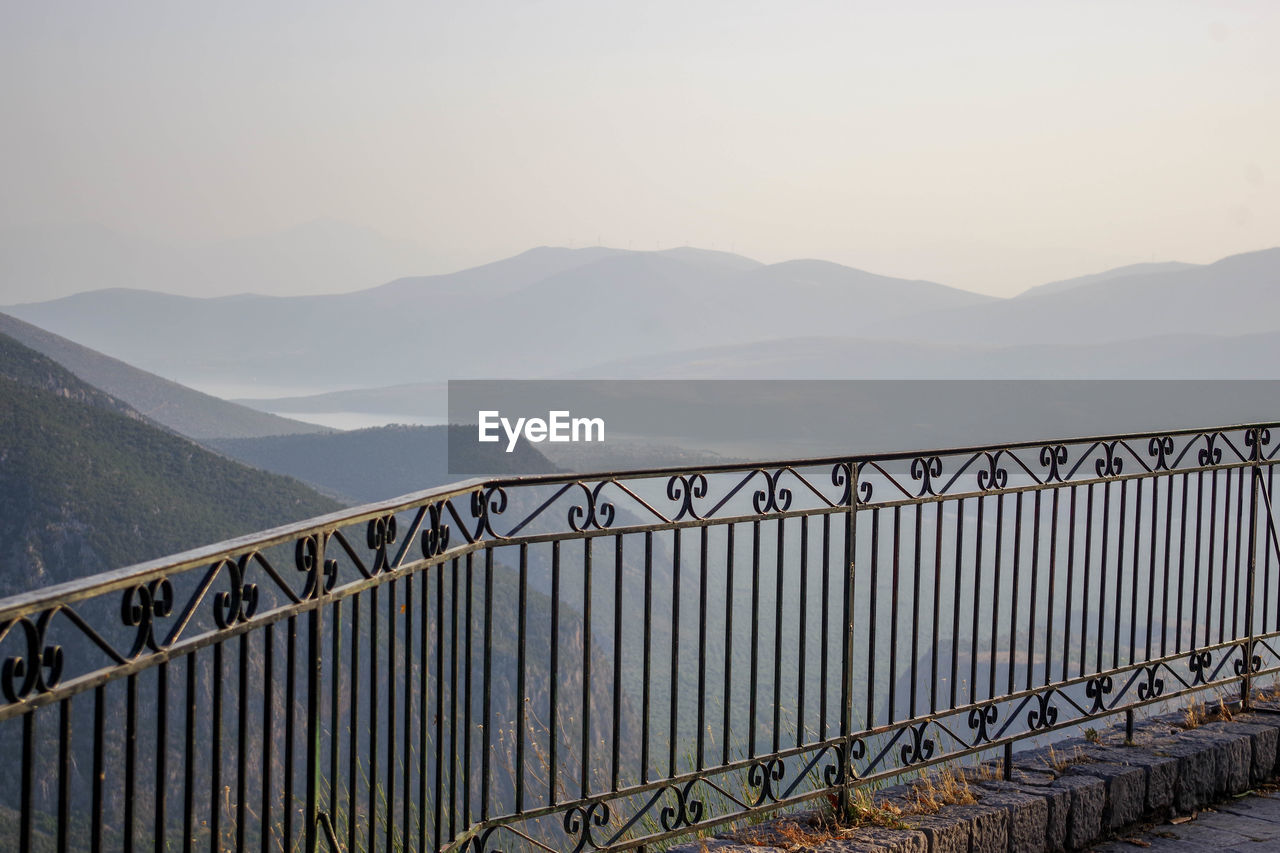 mountain, sky, nature, railing, scenics - nature, architecture, environment, mountain range, fog, beauty in nature, water, no people, landscape, built structure, tranquility, travel, tranquil scene, bridge, travel destinations, outdoors, transportation, land, day, tourism, non-urban scene, metal