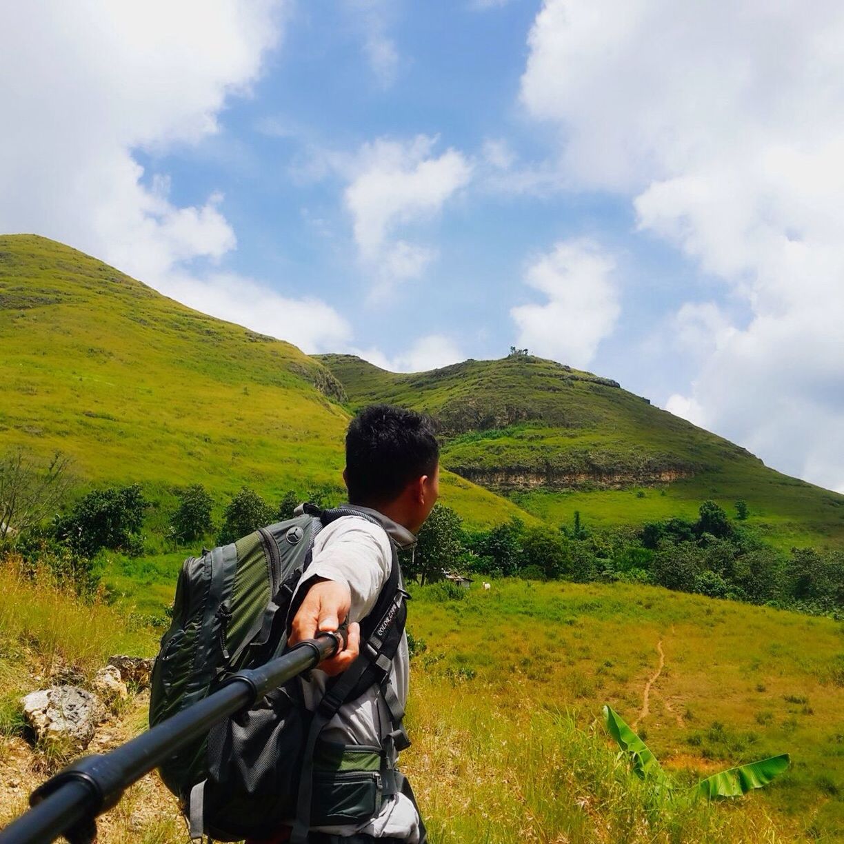 Male hiker taking selfie with monopod on mountain
