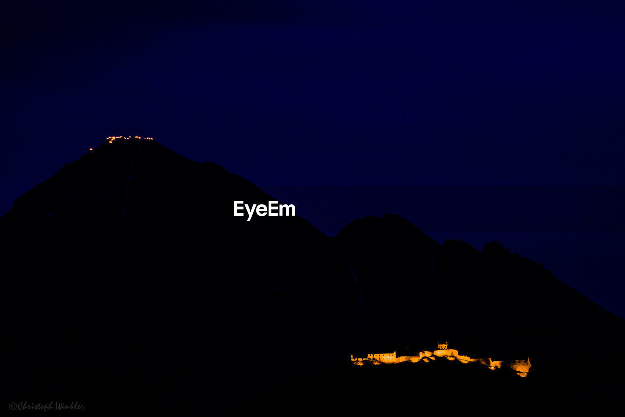 SILHOUETTE MOUNTAIN RANGE AGAINST CLEAR BLUE SKY AT NIGHT