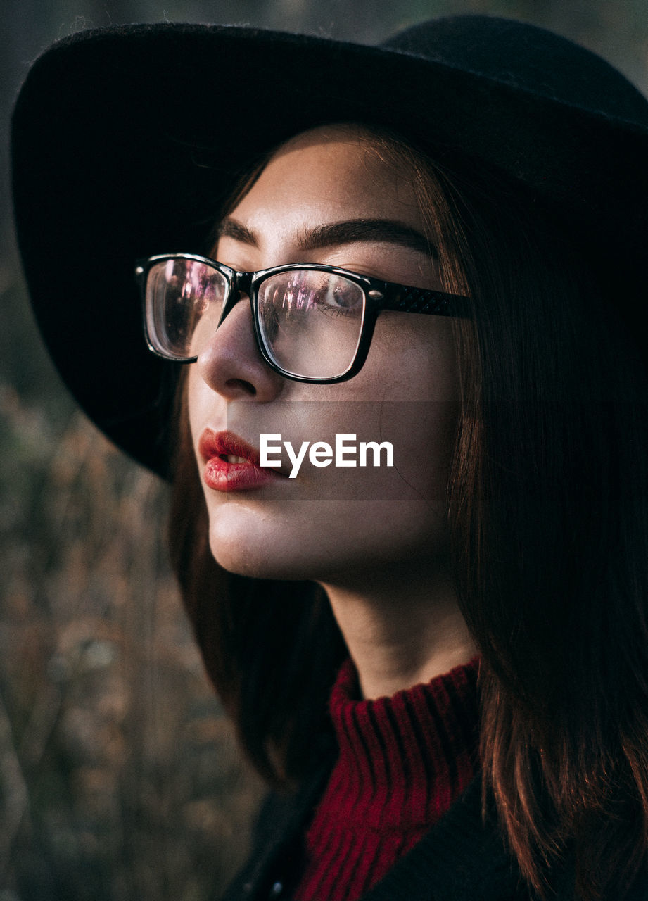 CLOSE-UP PORTRAIT OF YOUNG WOMAN IN EYEGLASSES