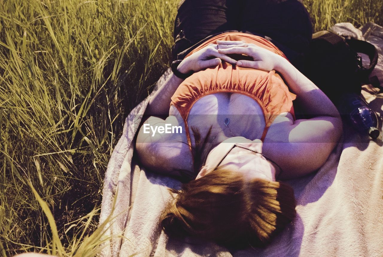 High angle view of a young woman lying on grass