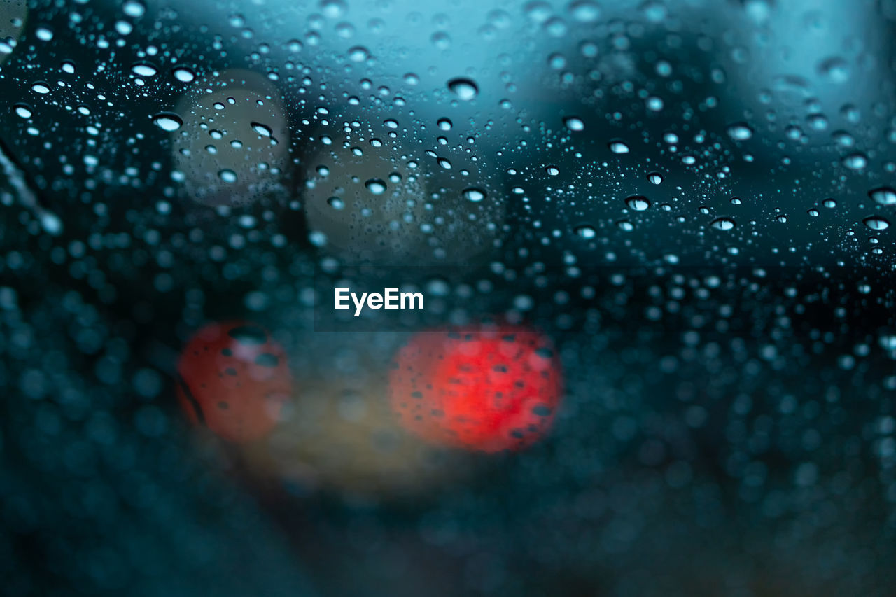 Close-up of wet glass window during rainy season