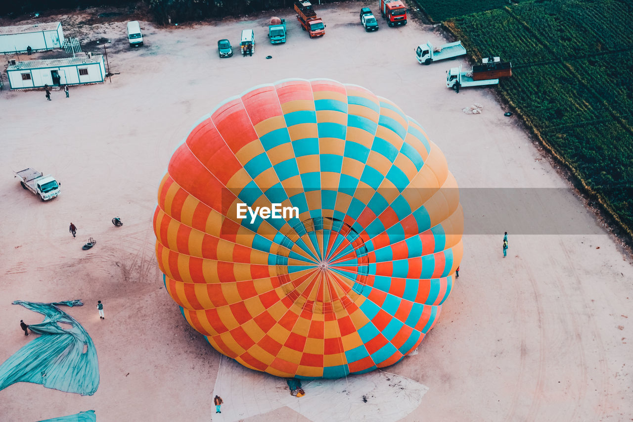 multi colored, blue, high angle view, land, beach, circle, day, toy, sand, nature, transportation, outdoors, geometric shape, shape, architecture, holiday, city, vacation, mode of transportation, travel, trip, vehicle, group of people, water, travel destinations