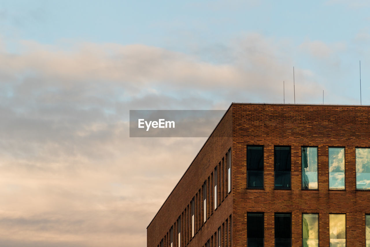 LOW ANGLE VIEW OF BUILDING AGAINST SKY AT SUNSET