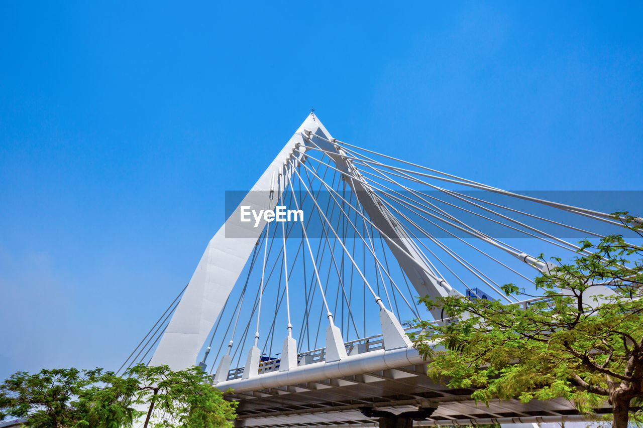 LOW ANGLE VIEW OF MODERN BRIDGE AGAINST CLEAR BLUE SKY