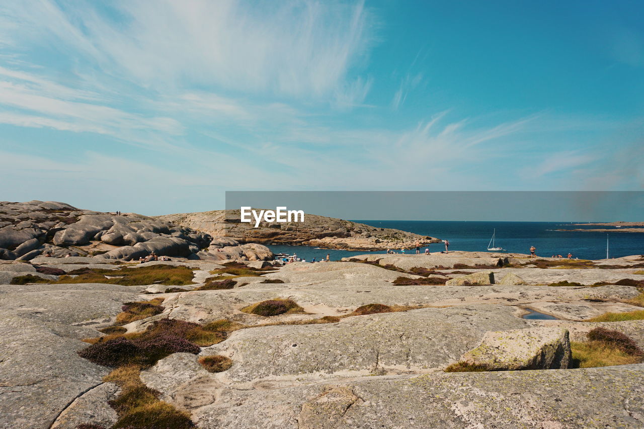 Scenic view of rocky shore against sky