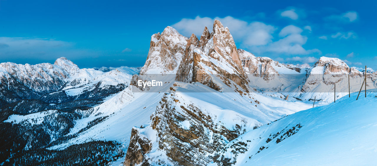 Scenic view of snowcapped mountains against blue sky