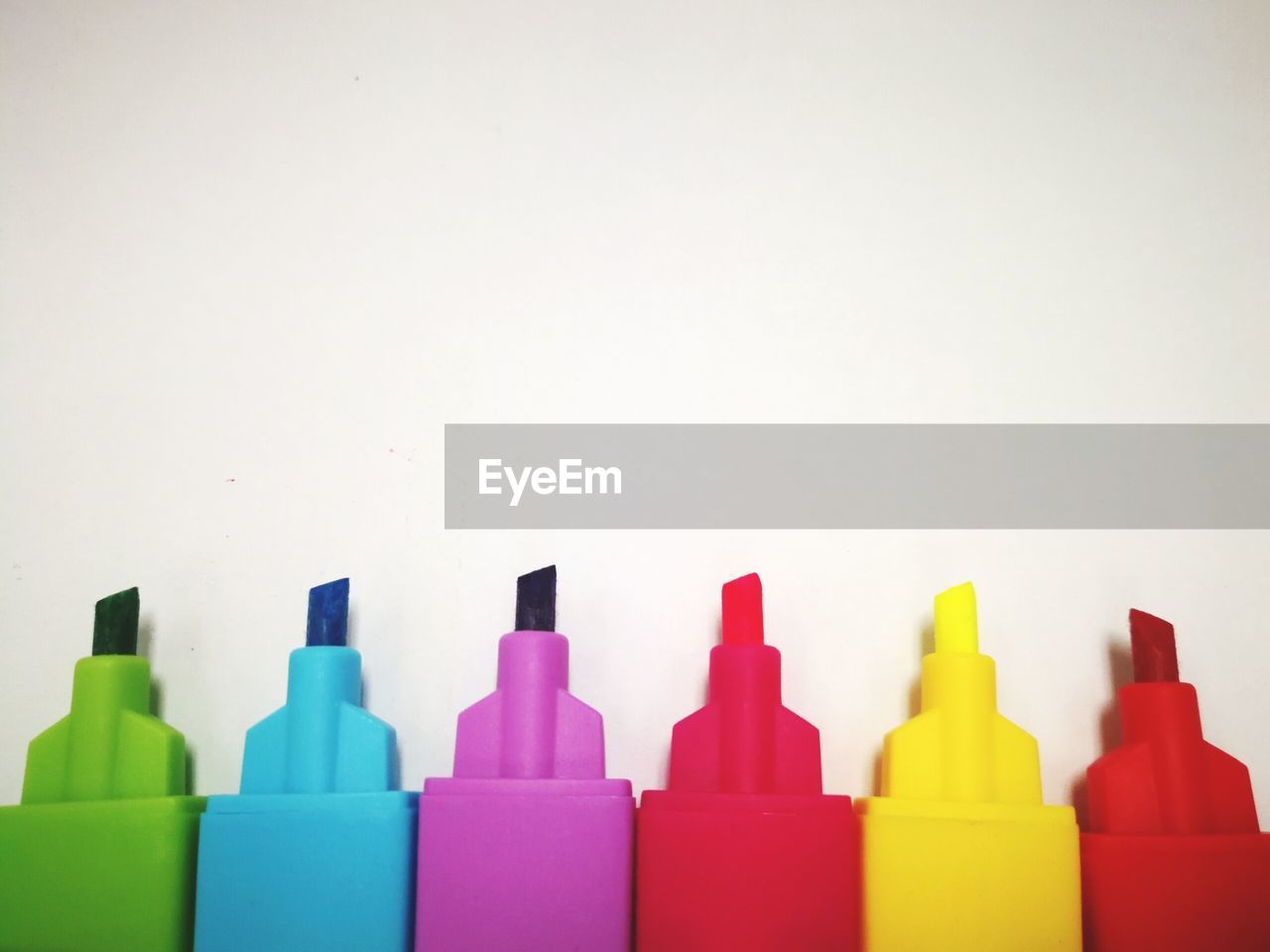 Close-up of colored pencils over white background