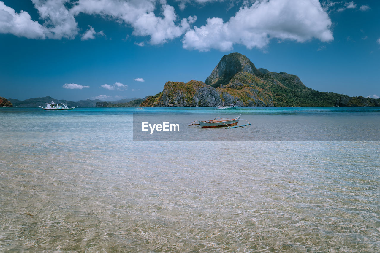 SCENIC VIEW OF SEA AGAINST MOUNTAINS