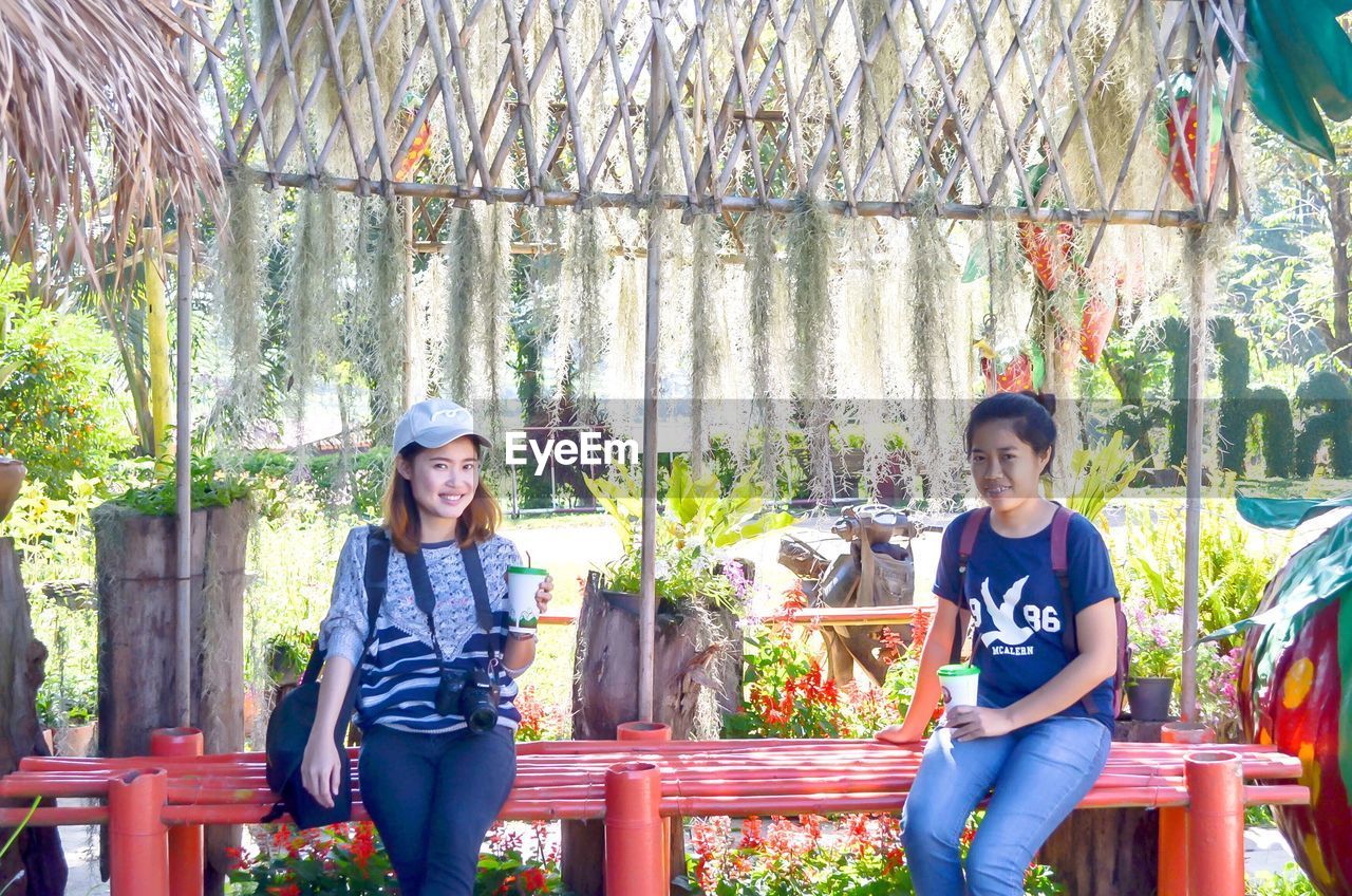 FULL LENGTH OF HAPPY BOY SMILING IN GREENHOUSE