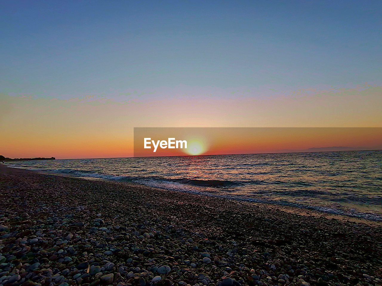 SCENIC VIEW OF SUNSET OVER SEA