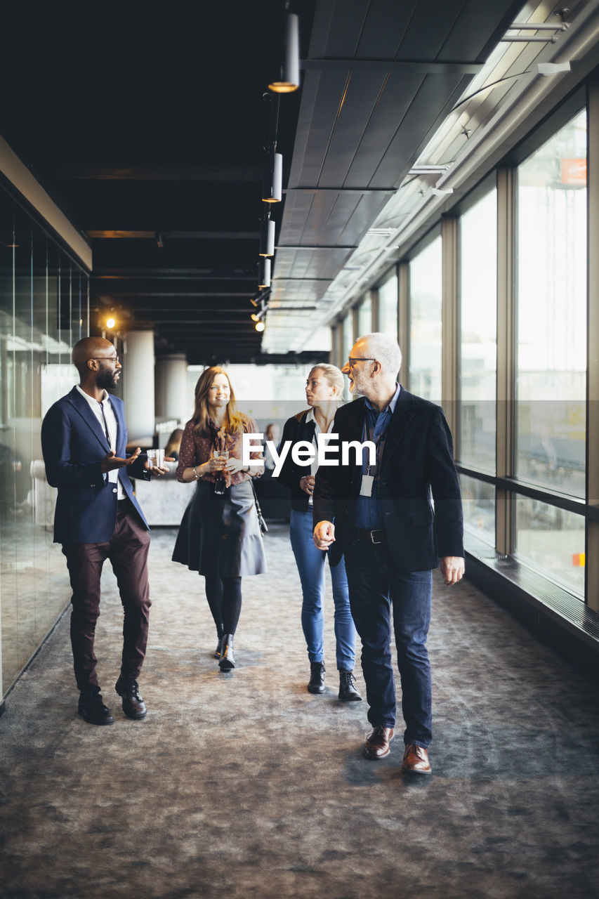 Female and male entrepreneurs walking in office corridor