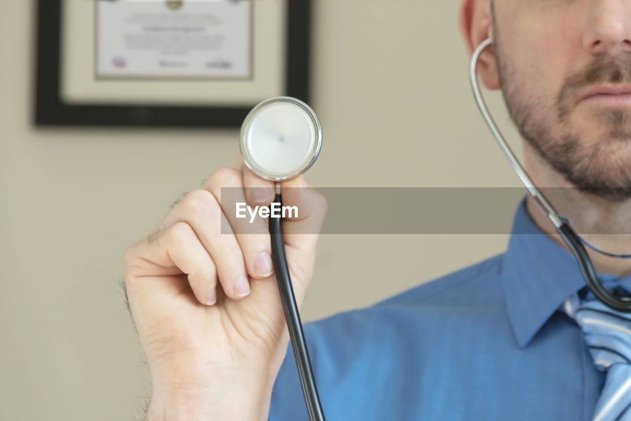 Doctor holding up stethoscope while on video chat diagnosis.