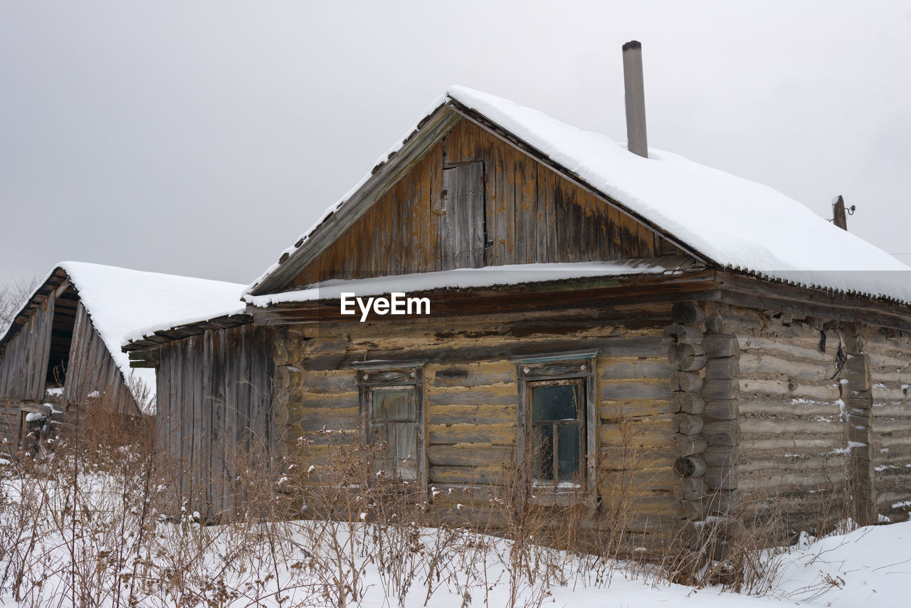 Abandoned wooden house in the russian village in winter