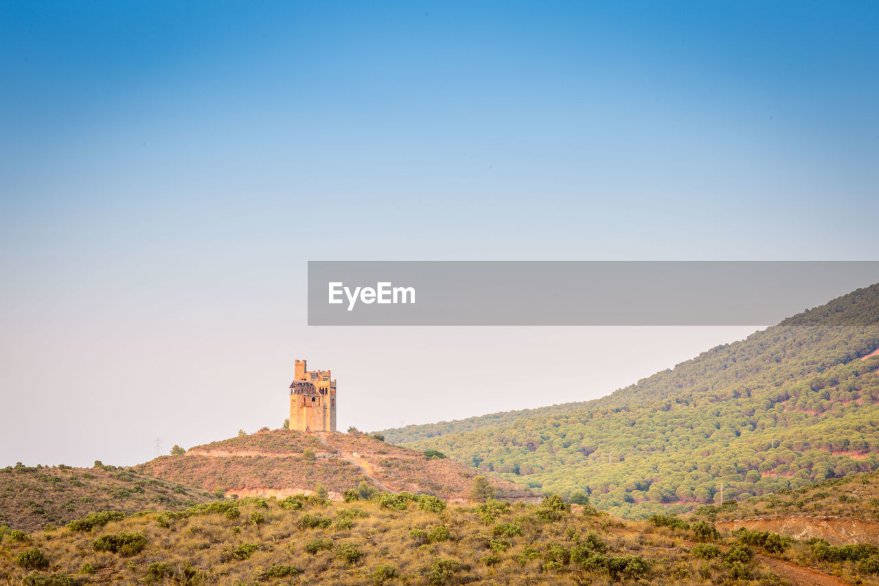 VIEW OF LIGHTHOUSE AGAINST MOUNTAIN