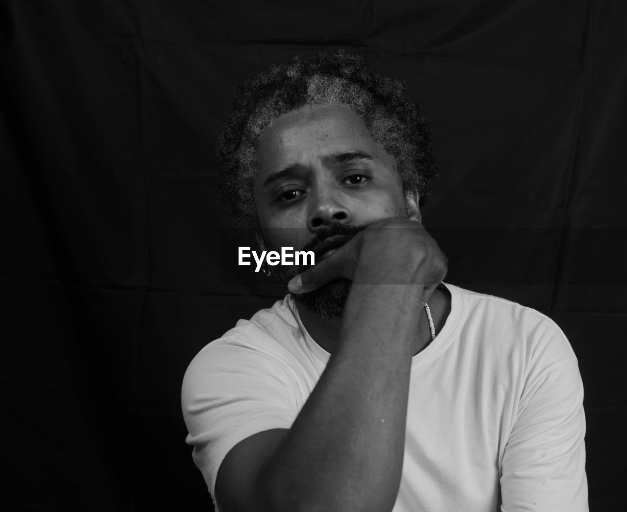 Young man looking away against black background