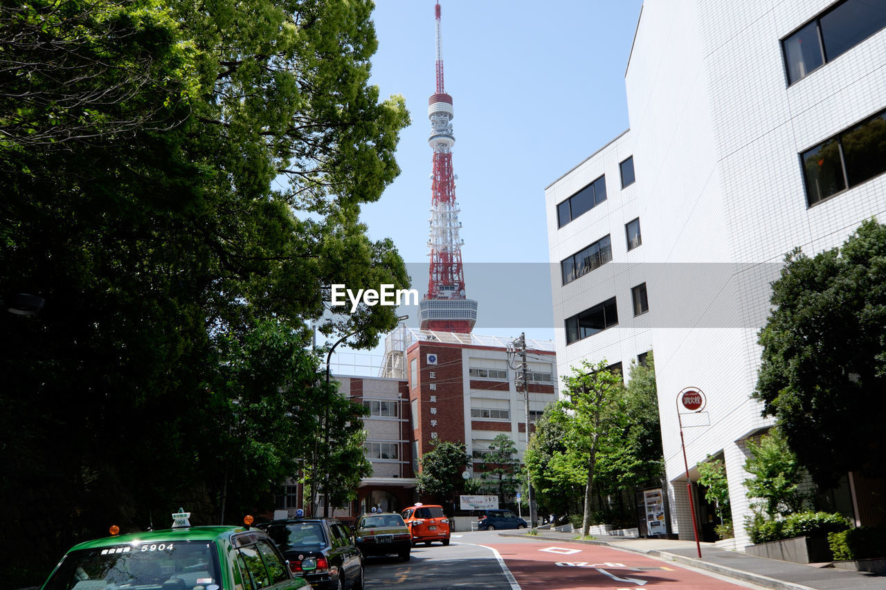 City street by tokyo tower against clear sky