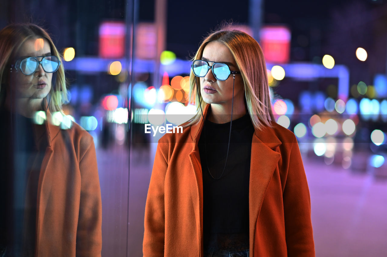 Portrait of young woman looking away at night