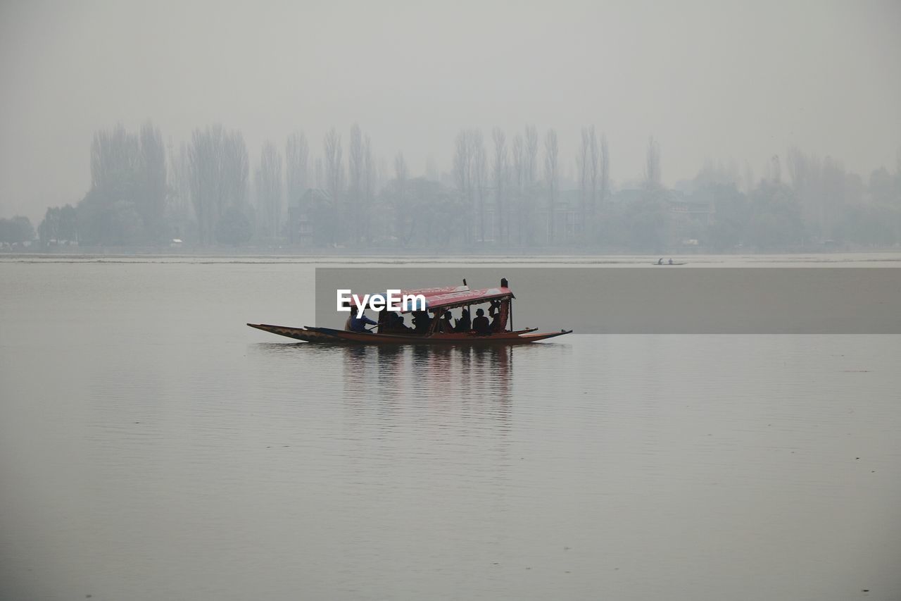 Boat in lake against sky during foggy weather