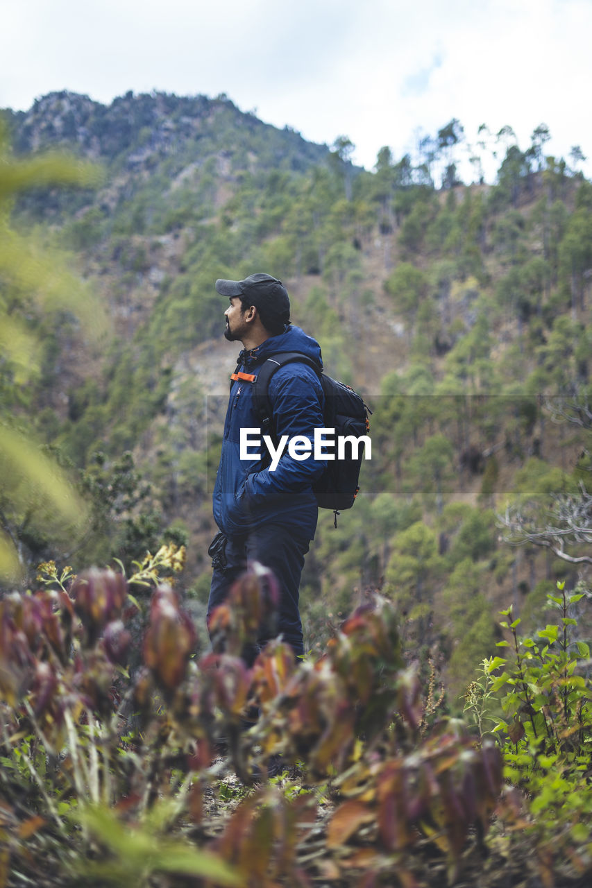 Hipster young boy with backpack enjoying trekking sunset on the mountains. tourist traveler.