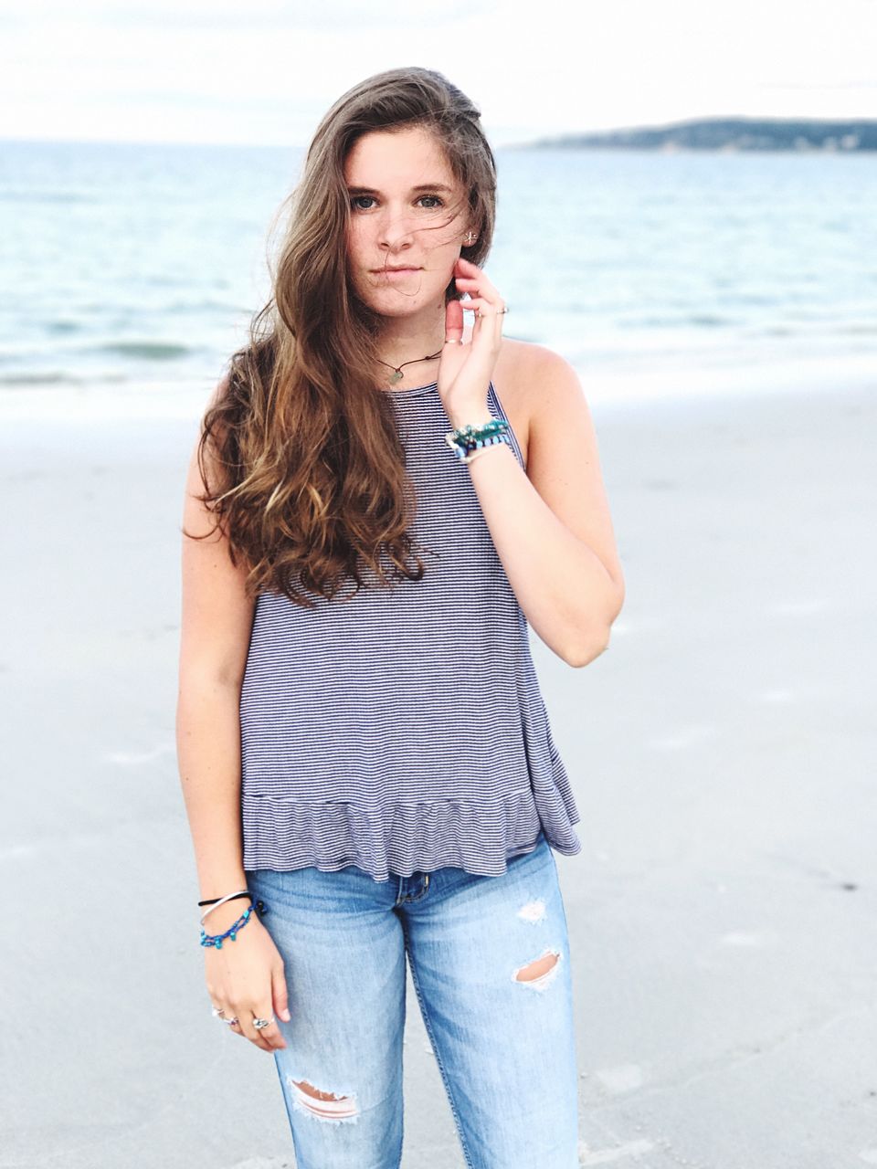 Portrait of beautiful woman standing on shore at beach