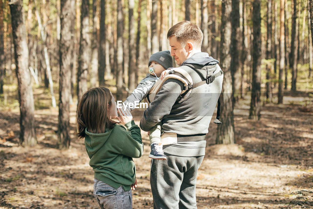 Rear view of father and son in forest