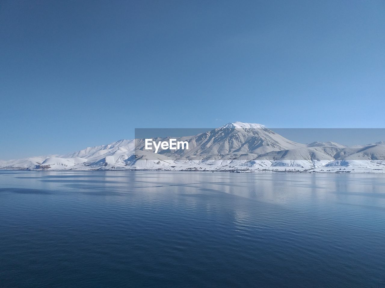 Scenic view of snowcapped mountains against clear blue sky