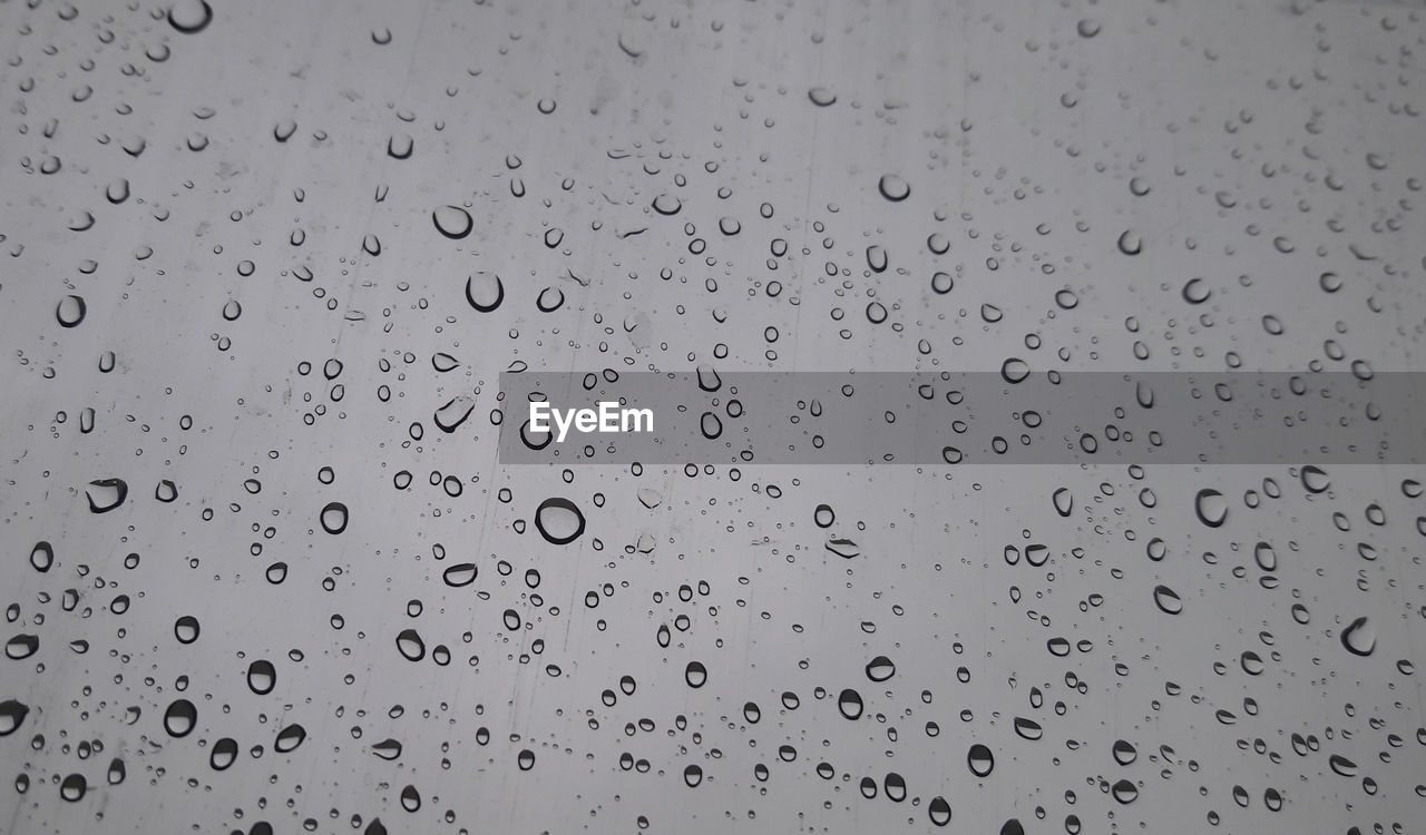 FULL FRAME SHOT OF WATER DROPS ON GLASS WINDOW