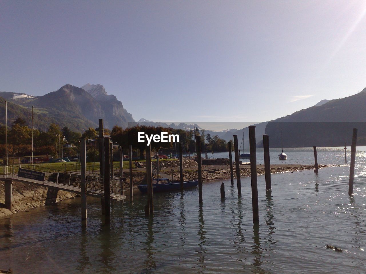 Pier on calm lake against mountain range