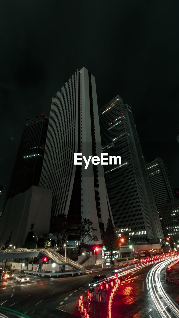 ILLUMINATED CITY STREET AND BUILDINGS AGAINST SKY