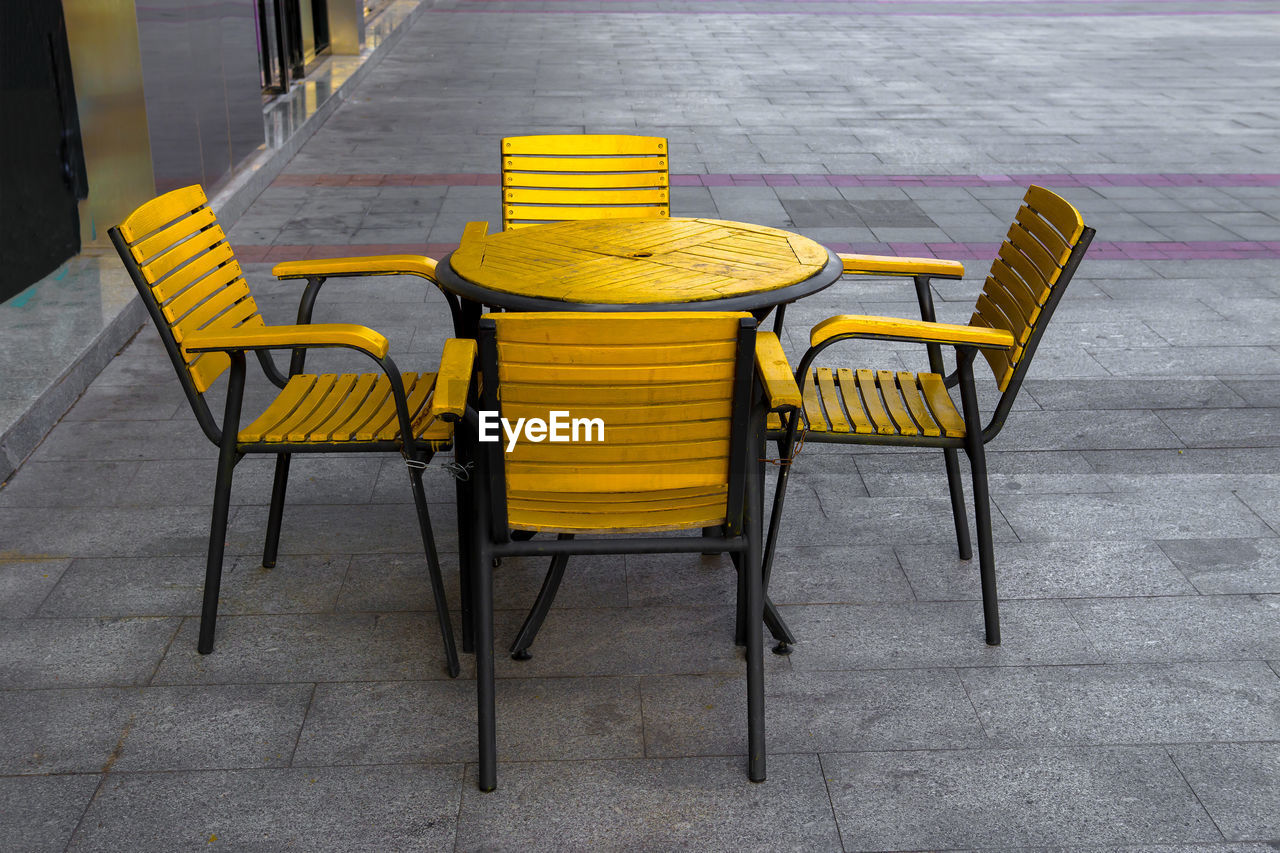 EMPTY CHAIRS AND TABLE ON SIDEWALK CAFE