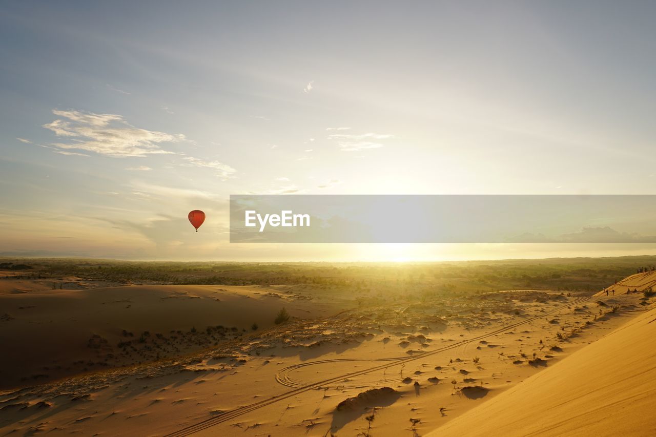 Hot air balloon flying over desert 