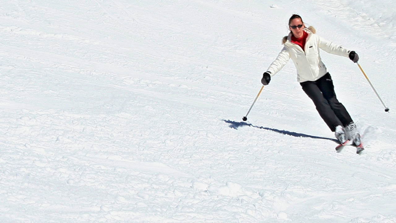 Low angle view of woman skiing on snow covered mountain