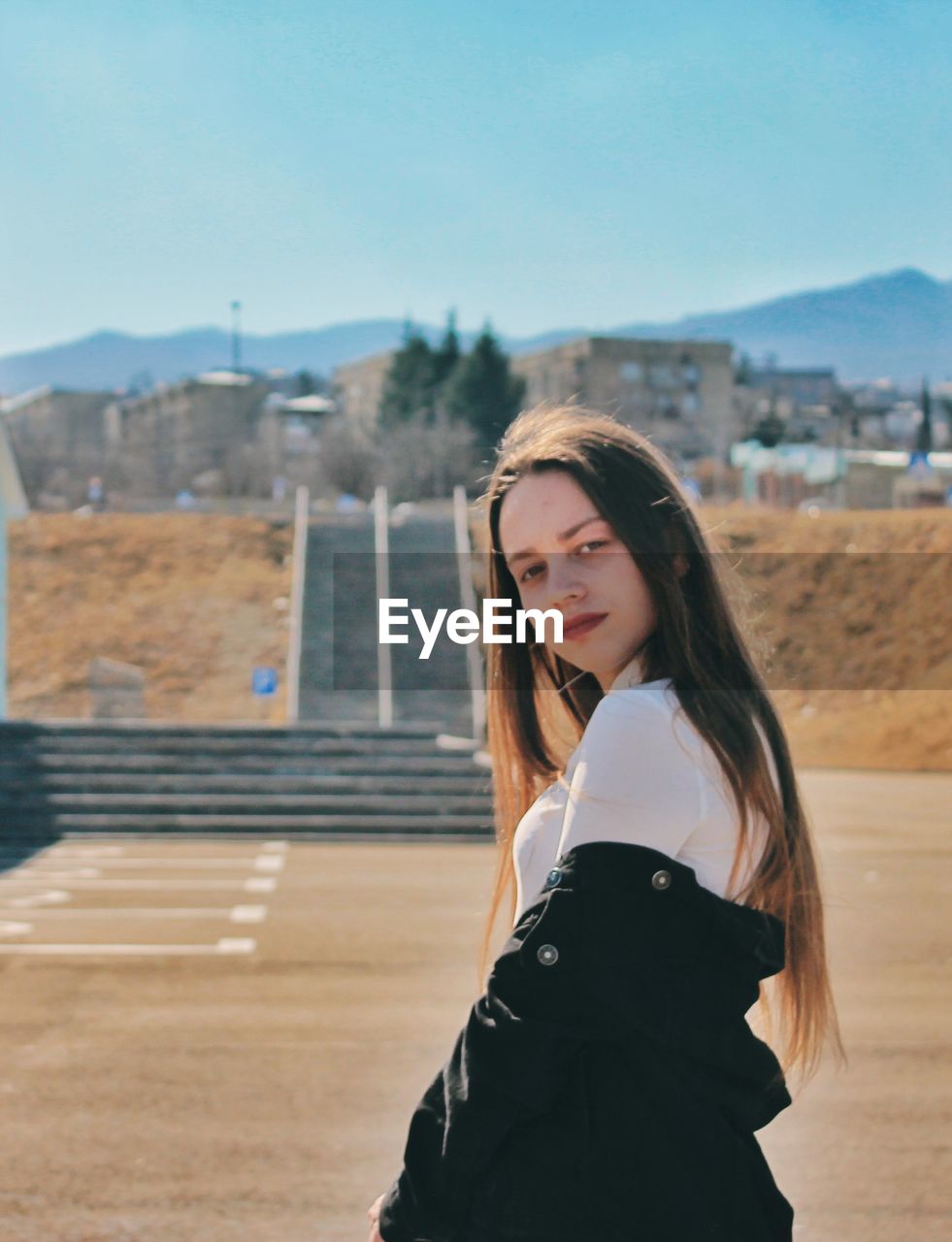 Portrait of beautiful woman standing against sky