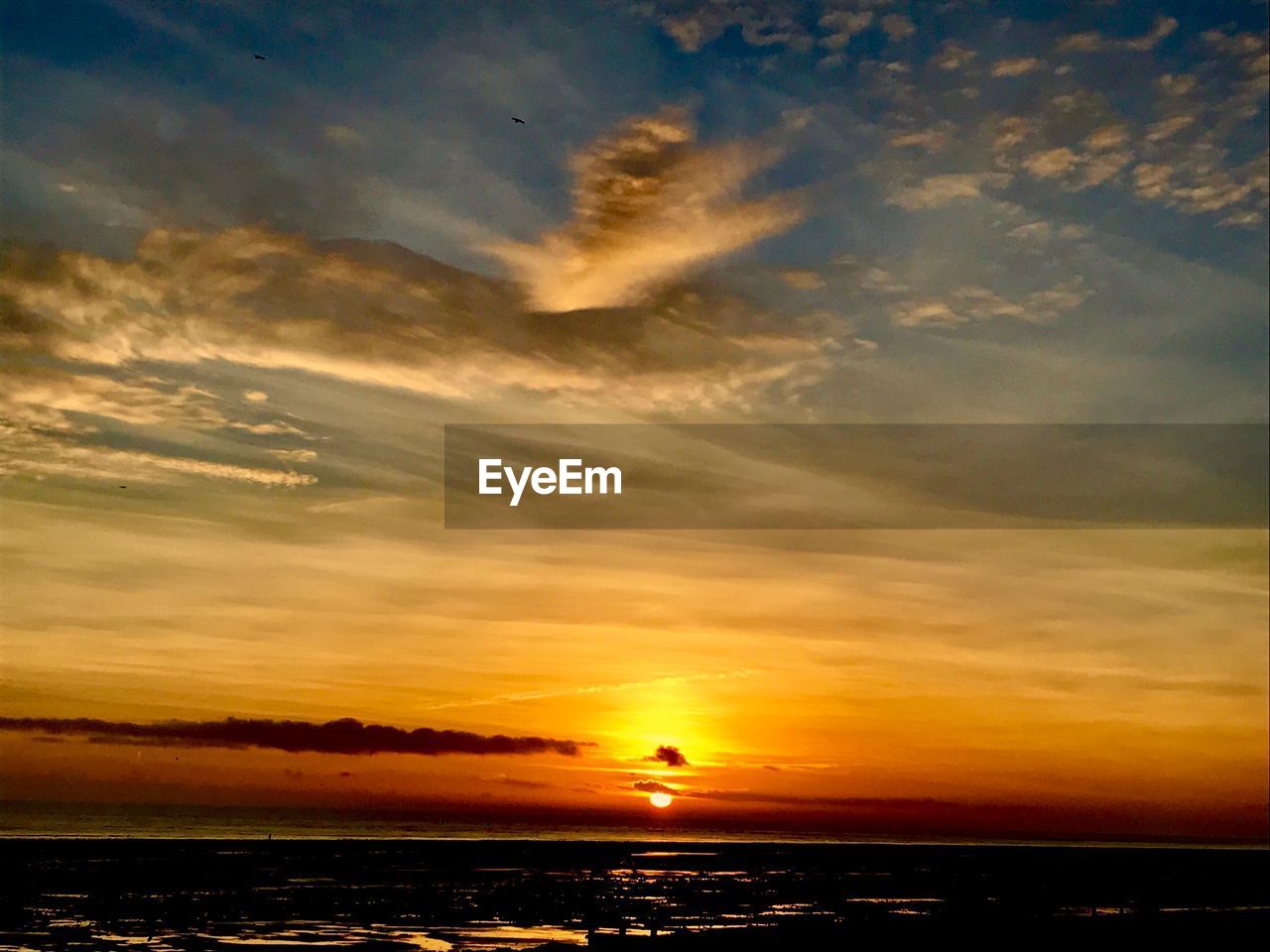 Scenic view of dramatic sky over sea during sunset