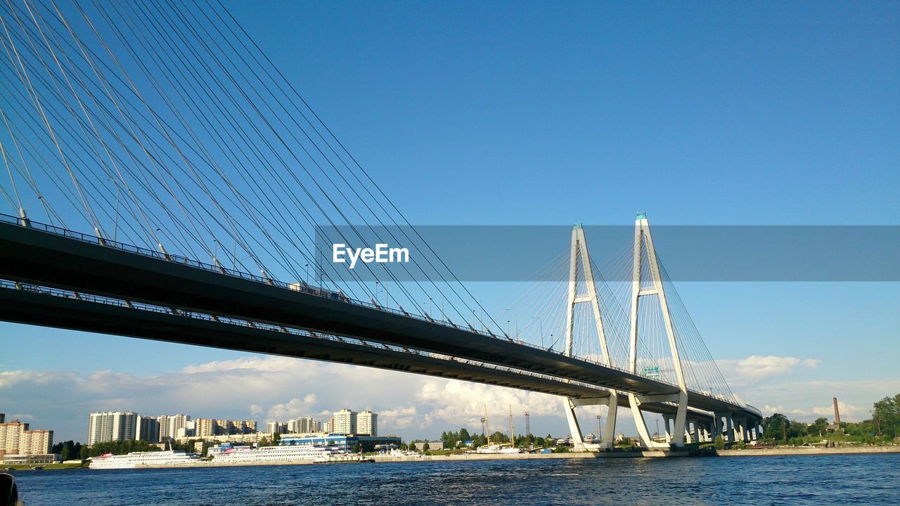Suspension bridge over river against sky