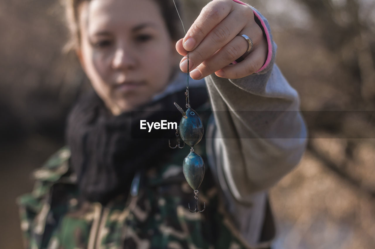 Close-up of woman holding blue fishing bait