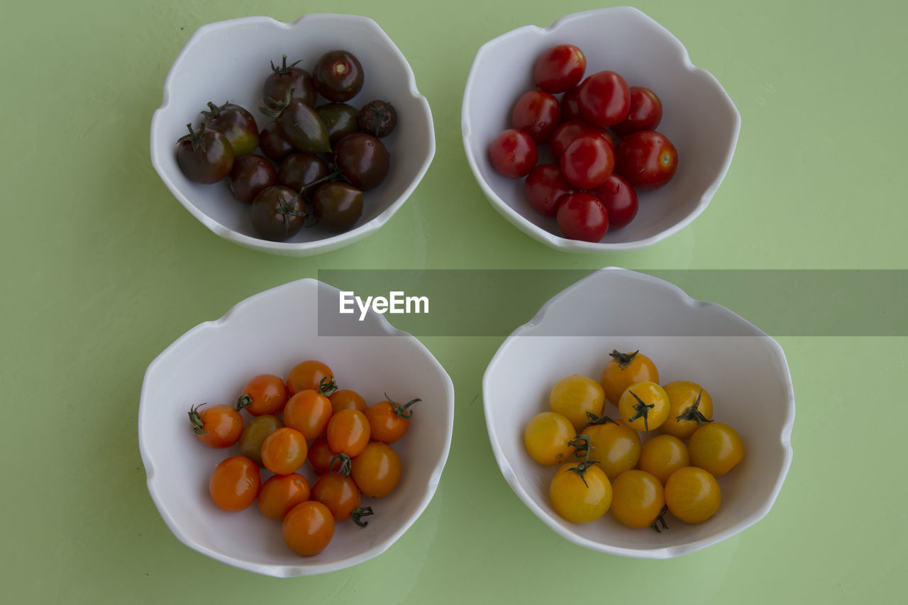 High angle view of four bowls with variety of tomatoes