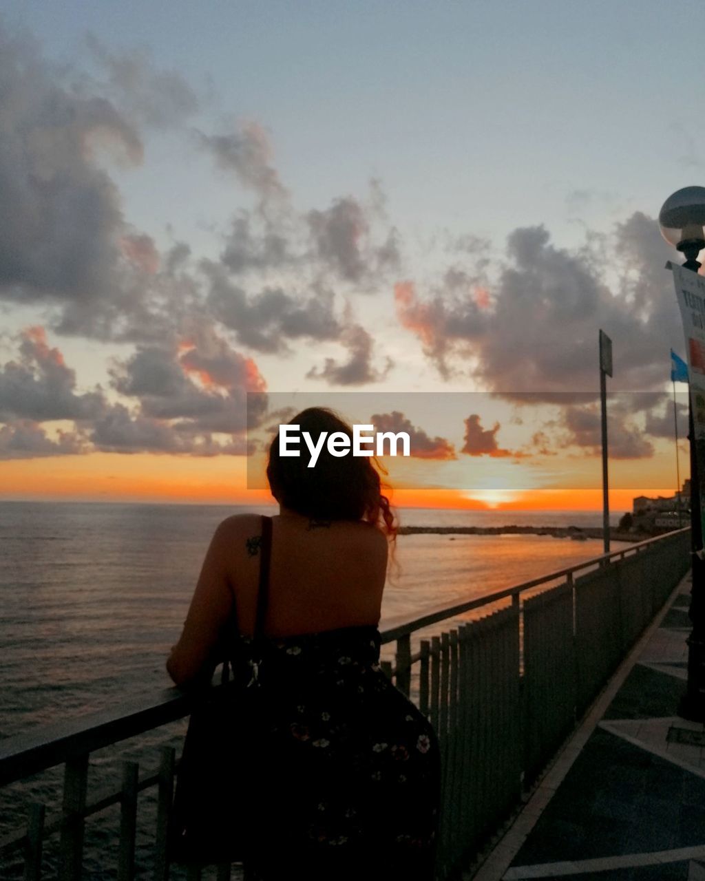 REAR VIEW OF MAN LOOKING AT SEA AGAINST SKY