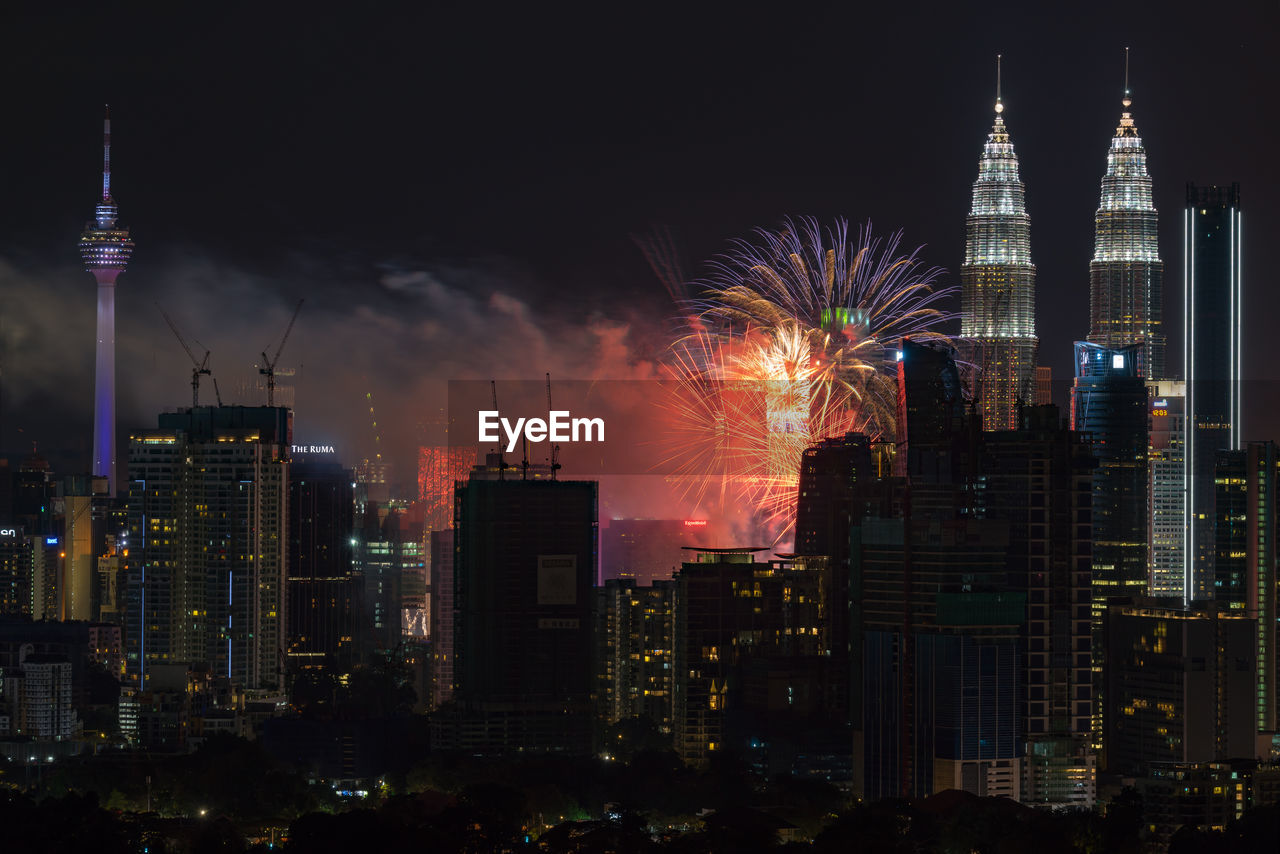 Illuminated cityscape against sky at night