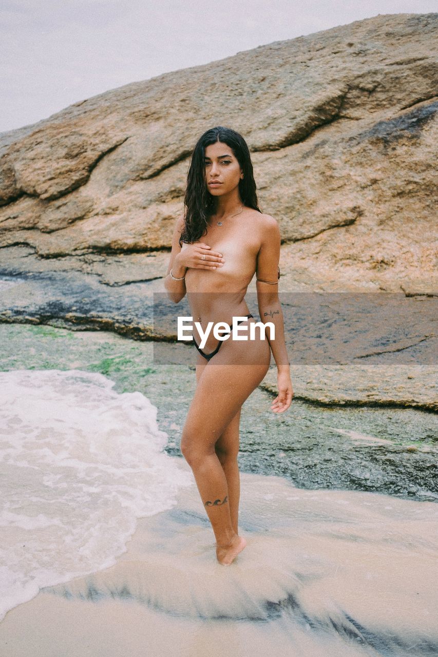 Young woman in bikini standing on beach