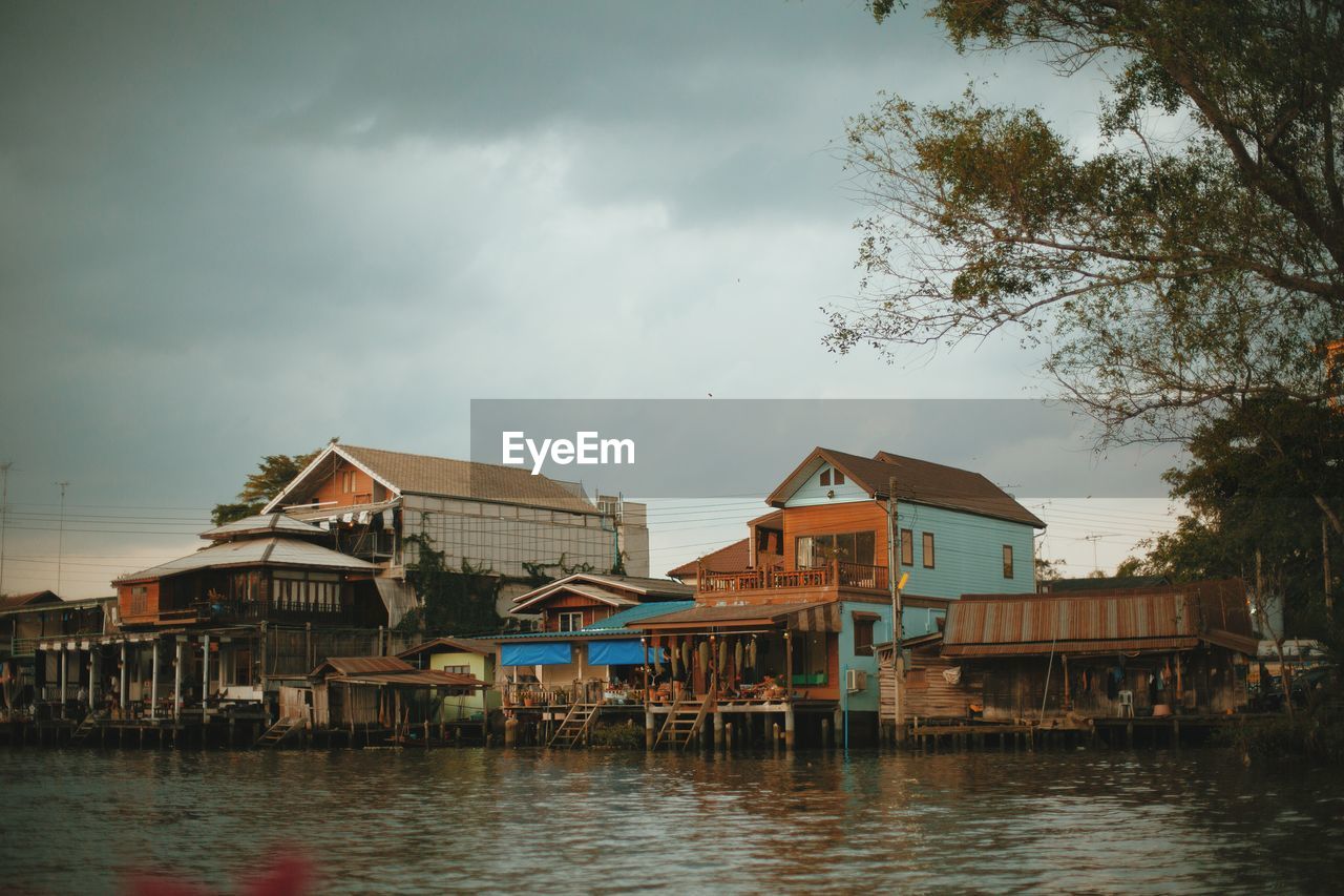 HOUSES BY RIVER AGAINST BUILDINGS