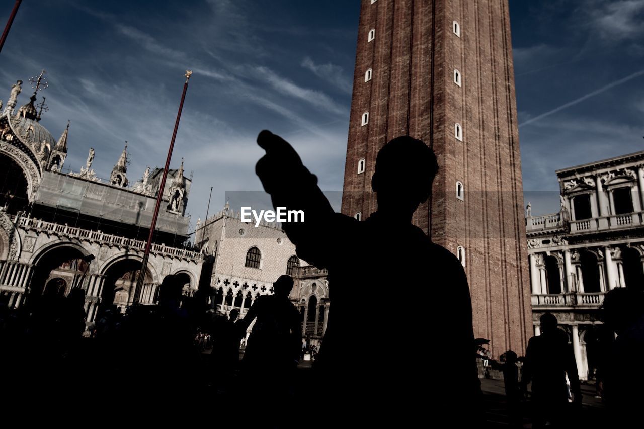 SILHOUETTE OF WOMAN STANDING AGAINST WALL