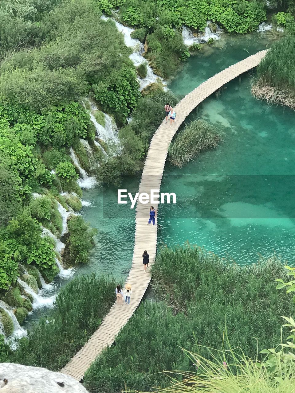 Aerial view of people on footbridge over lake