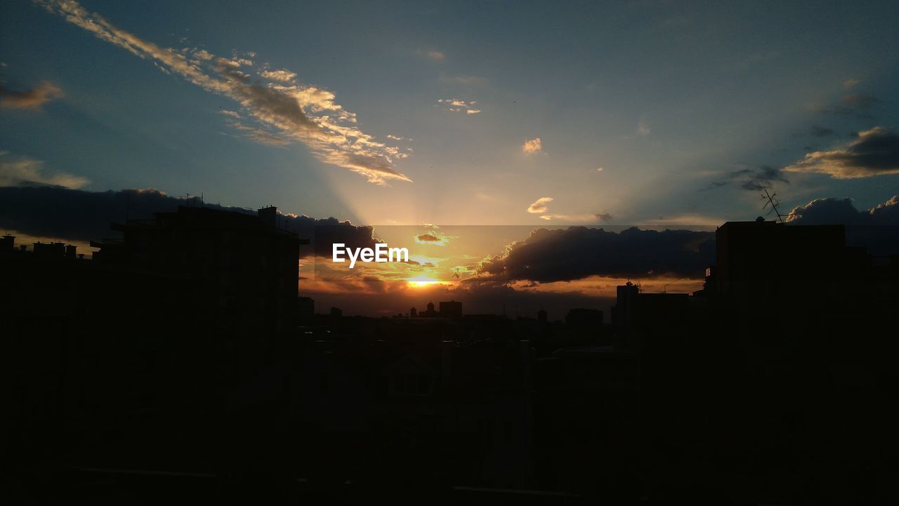 Silhouette cityscape against sky during sunset