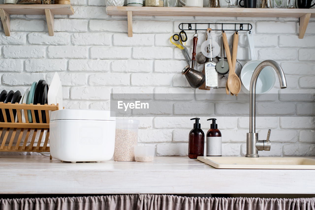 Electric smart rice cooker on wooden counter-top in the kitchen with brown rice