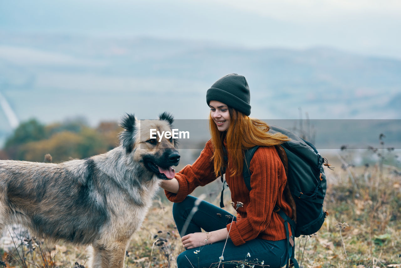 YOUNG WOMAN WITH DOG LOOKING AWAY