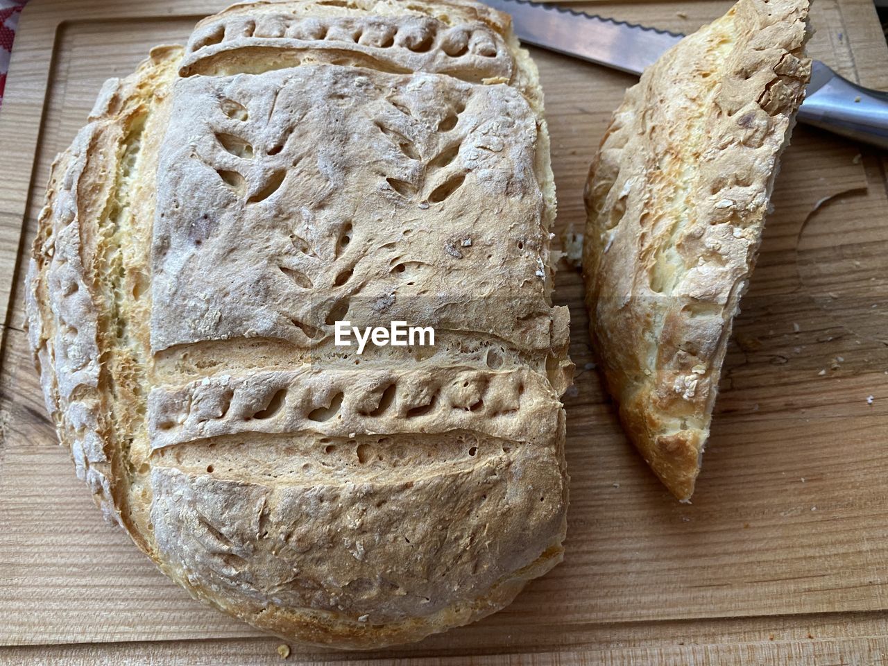 food, food and drink, baked, freshness, bread, wood, table, indoors, no people, high angle view, healthy eating, loaf of bread, whole grain, still life, wellbeing, flour, rye bread, close-up, sourdough, cutting board, bakery, fast food, store, ciabatta, directly above
